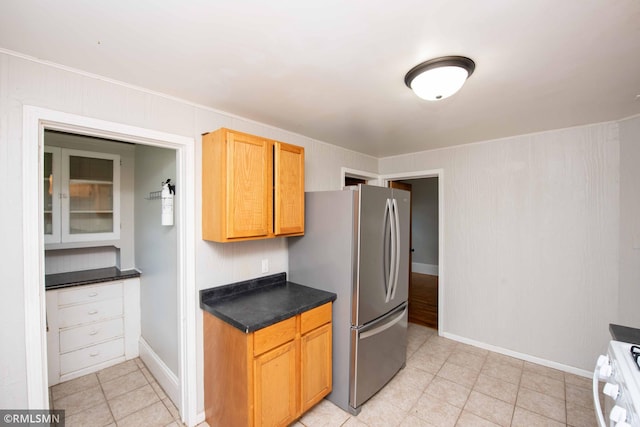 kitchen featuring stainless steel fridge, white range oven, and light tile patterned floors