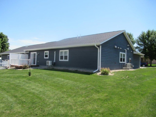 rear view of property featuring a yard and ac unit