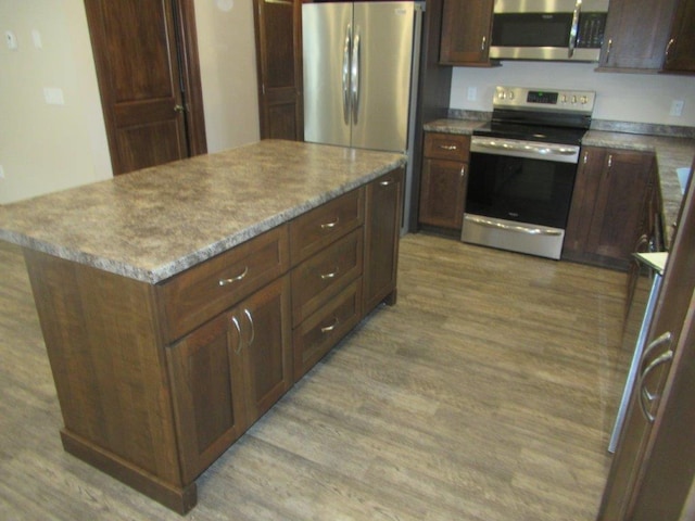 kitchen featuring a kitchen island, light wood-type flooring, and stainless steel appliances