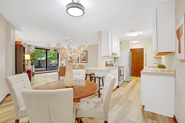 dining area featuring light hardwood / wood-style flooring, a textured ceiling, and sink