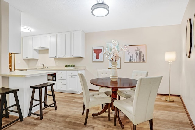 dining area with sink and light hardwood / wood-style flooring