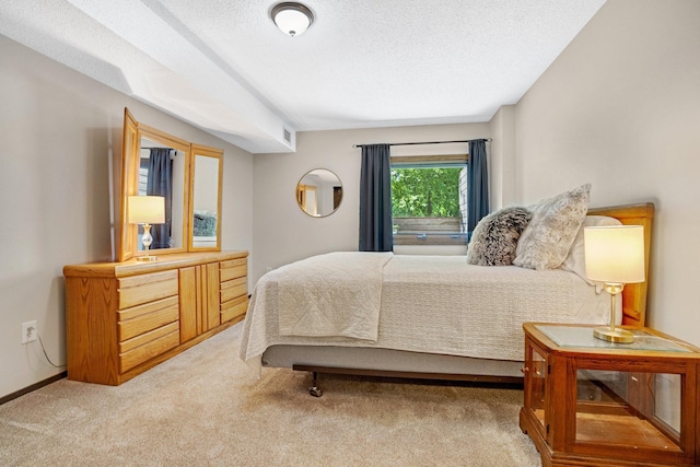bedroom featuring a textured ceiling, carpet floors, baseboards, and visible vents
