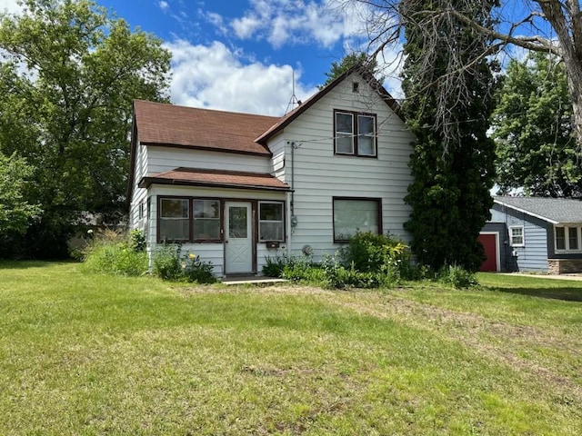 rear view of house featuring a lawn