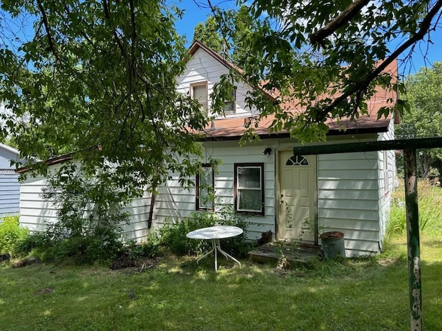 rear view of property featuring a lawn