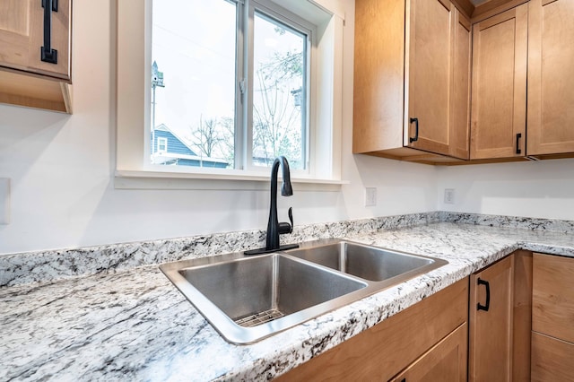 room details with light stone countertops and sink