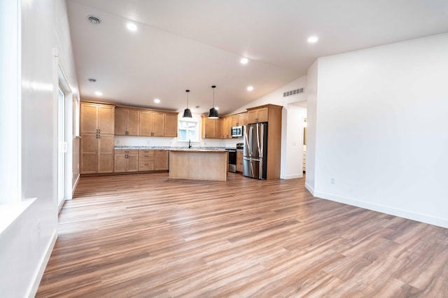 kitchen featuring a center island, light hardwood / wood-style floors, stainless steel appliances, vaulted ceiling, and decorative light fixtures