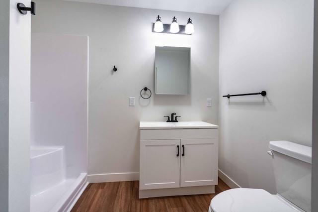 bathroom featuring vanity, hardwood / wood-style floors, toilet, and walk in shower