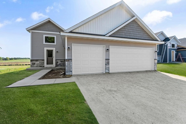 view of front of property with stone siding, a garage, concrete driveway, and a front yard