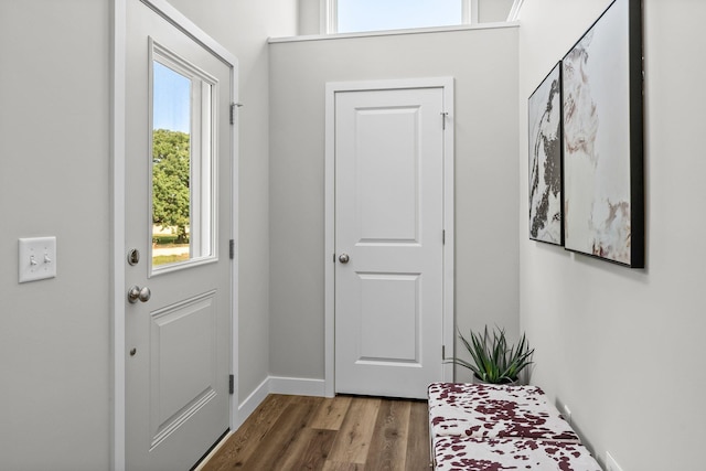 doorway with wood finished floors and baseboards