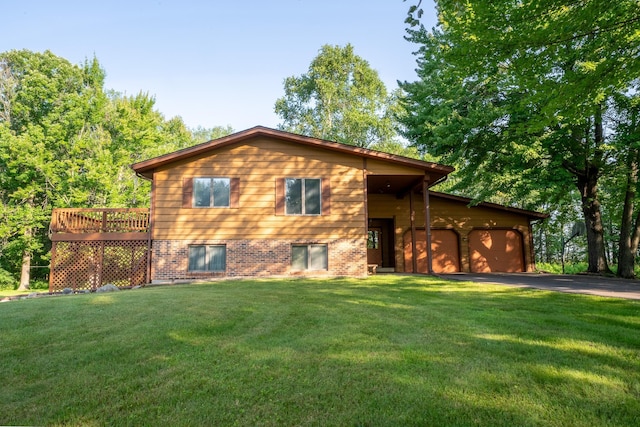 view of front of property with a front yard, a deck, and a garage