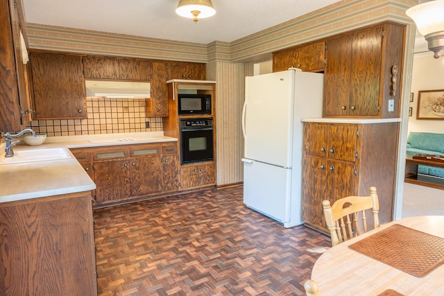 kitchen with dark parquet flooring, backsplash, black appliances, and sink