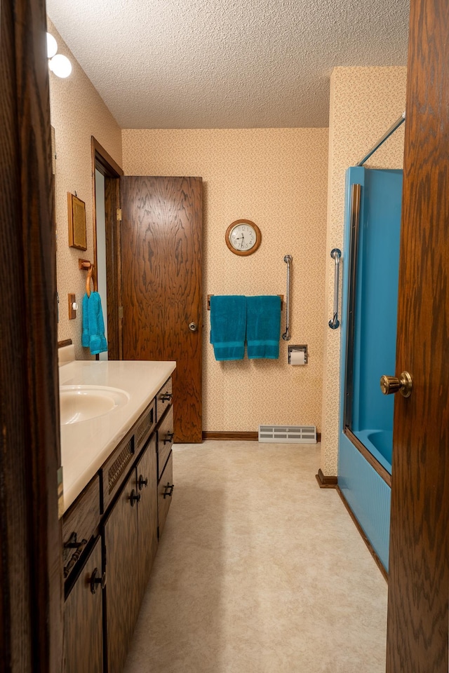 bathroom featuring vanity, a textured ceiling, and shower / bathtub combination