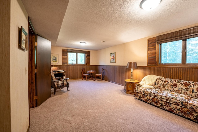 living room featuring wood walls, carpet, and a textured ceiling