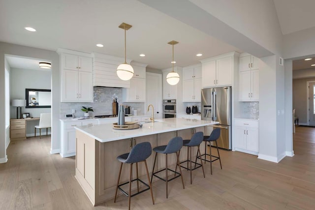 kitchen with decorative backsplash, light hardwood / wood-style flooring, and appliances with stainless steel finishes