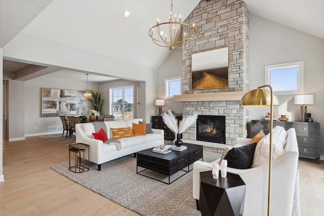 living room with plenty of natural light, a stone fireplace, hardwood / wood-style floors, and high vaulted ceiling