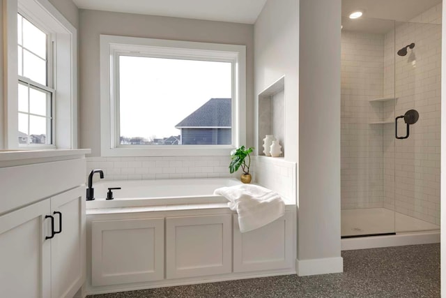 bathroom featuring shower with separate bathtub and plenty of natural light