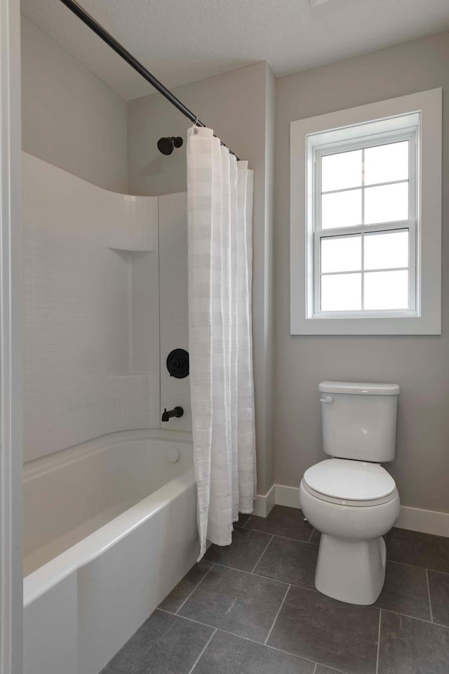 bathroom with shower / tub combo with curtain, tile patterned flooring, and toilet