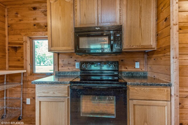 kitchen featuring wooden walls and black appliances