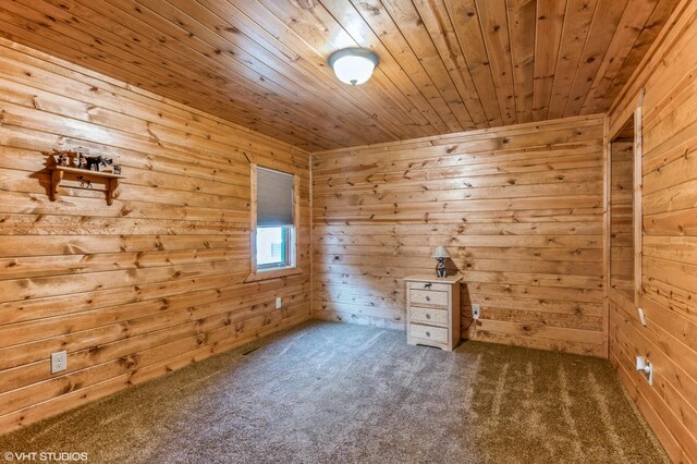 empty room with wooden walls, carpet flooring, and wooden ceiling