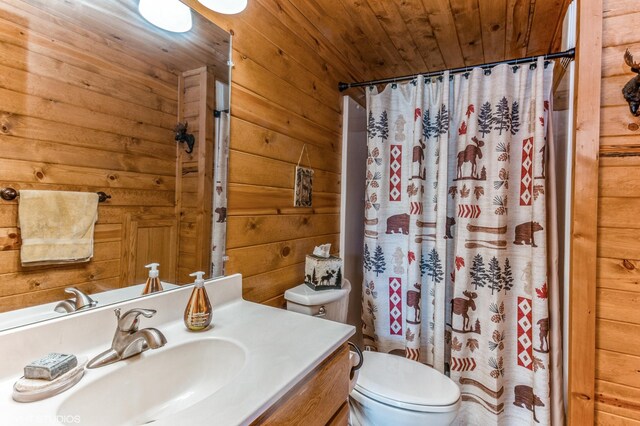 bathroom with curtained shower, wooden walls, vanity, toilet, and wooden ceiling