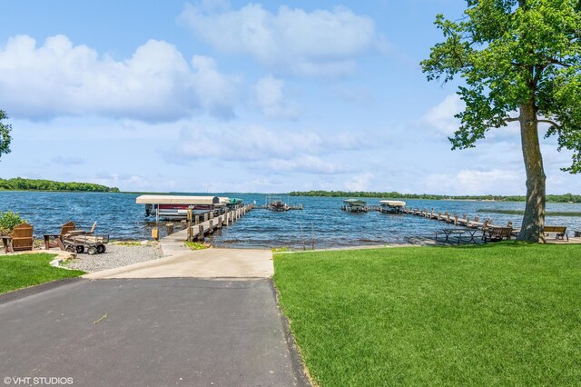 dock area featuring a water view and a lawn