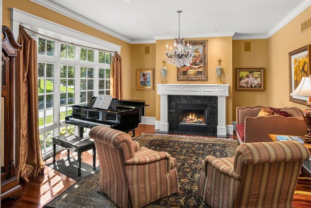 living room featuring a chandelier, crown molding, a fireplace, and hardwood / wood-style floors