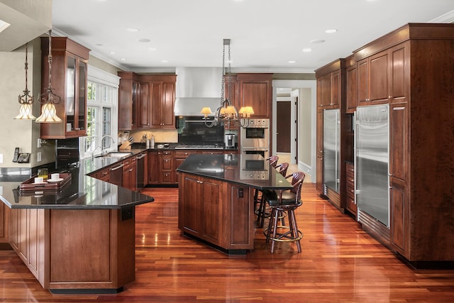 kitchen with a breakfast bar, sink, a center island, and stainless steel appliances