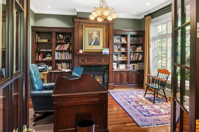 office space with an inviting chandelier, a high end fireplace, crown molding, and hardwood / wood-style flooring