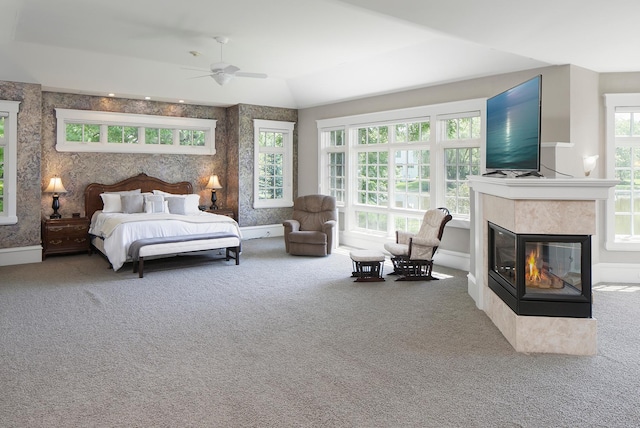 bedroom featuring ceiling fan, vaulted ceiling, carpet floors, and a multi sided fireplace