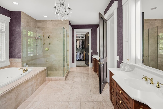 bathroom with an inviting chandelier, separate shower and tub, and vanity