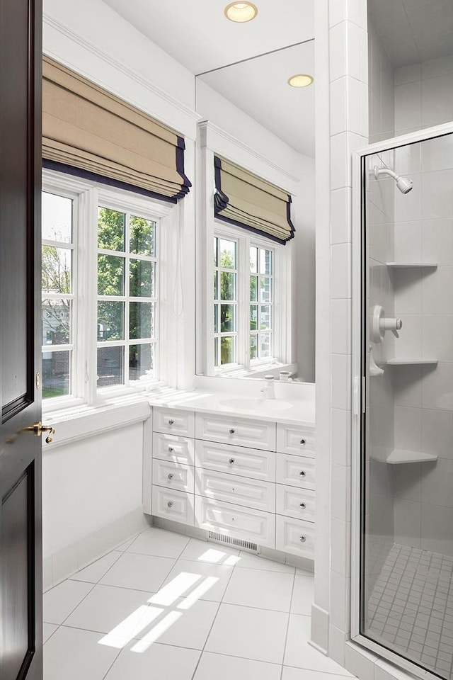 bathroom with a healthy amount of sunlight, tile patterned floors, and a shower with door