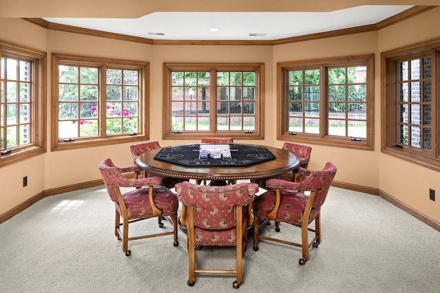 carpeted dining room with ornamental molding