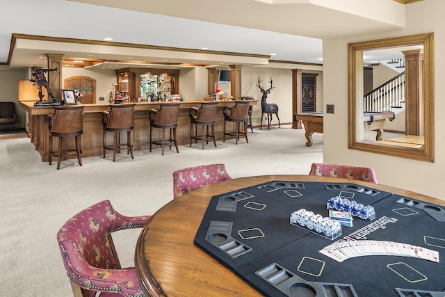 rec room with billiards, ornamental molding, decorative columns, light colored carpet, and bar area