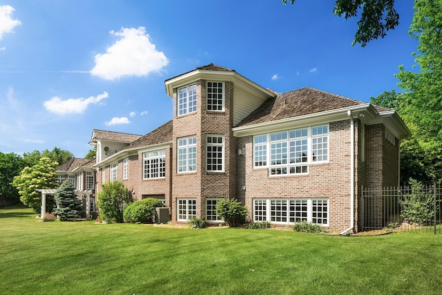 back of property featuring a lawn and central air condition unit