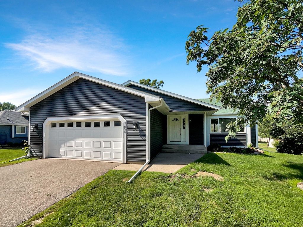 single story home featuring a front yard and a garage