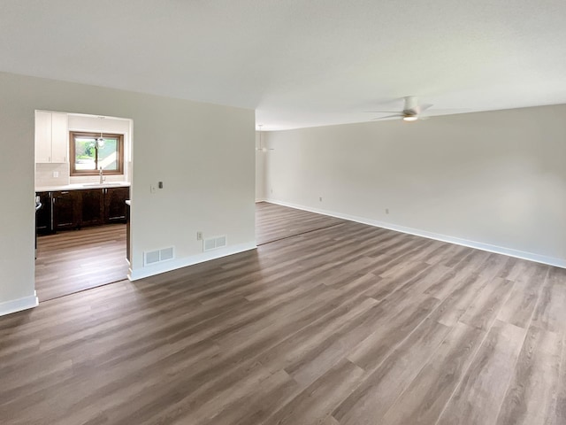 empty room with light hardwood / wood-style flooring, ceiling fan, and sink