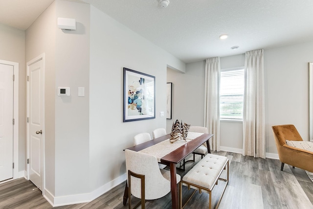 dining space with a textured ceiling and hardwood / wood-style flooring