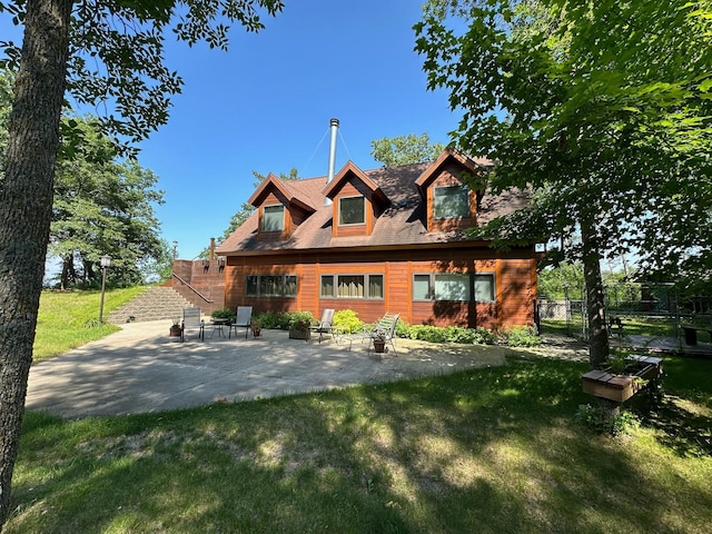 rear view of property featuring a patio and a lawn