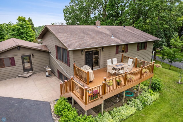 rear view of property with a lawn and a wooden deck