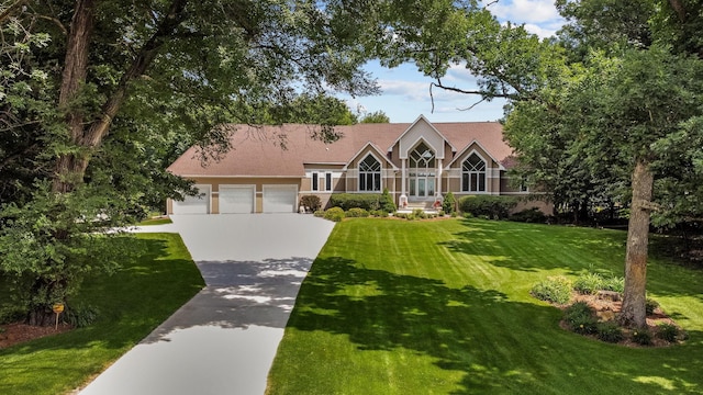 tudor home with a front yard and a garage