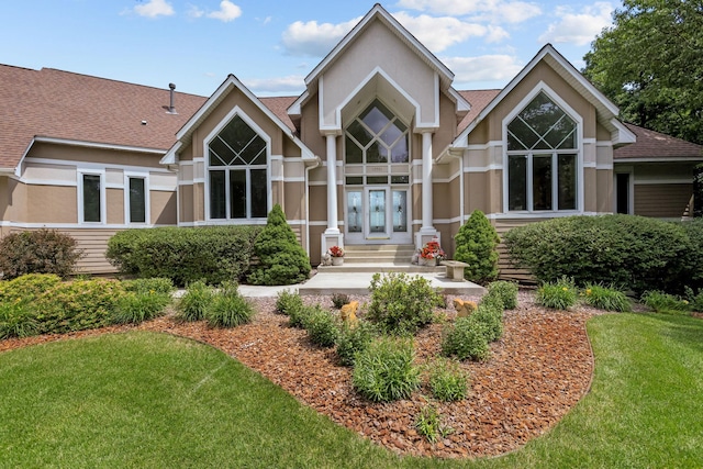 back of property with french doors and a yard