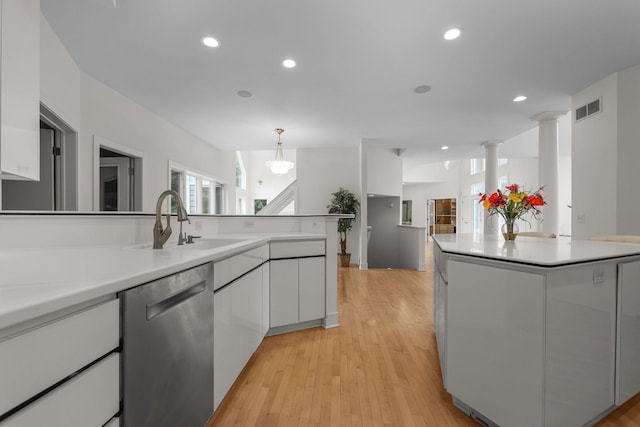 kitchen featuring pendant lighting, dishwasher, white cabinets, and sink