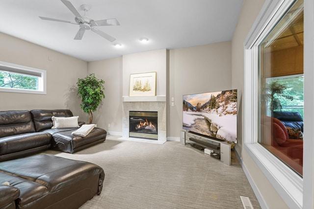 living room with ceiling fan, carpet flooring, and a tile fireplace