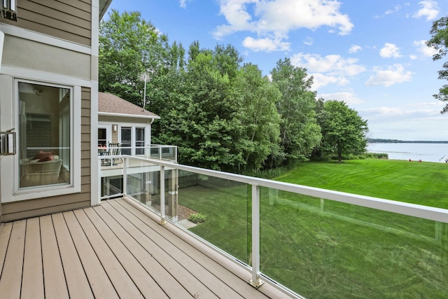 deck featuring a lawn and a water view