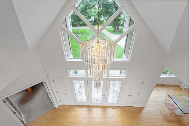 entrance foyer featuring a high ceiling, a chandelier, and light wood-type flooring