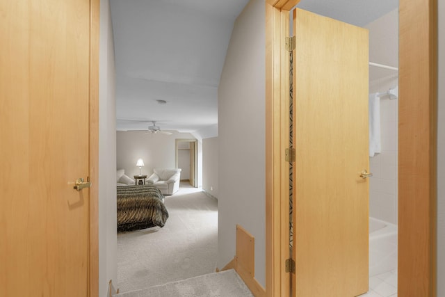 hallway featuring lofted ceiling and light carpet