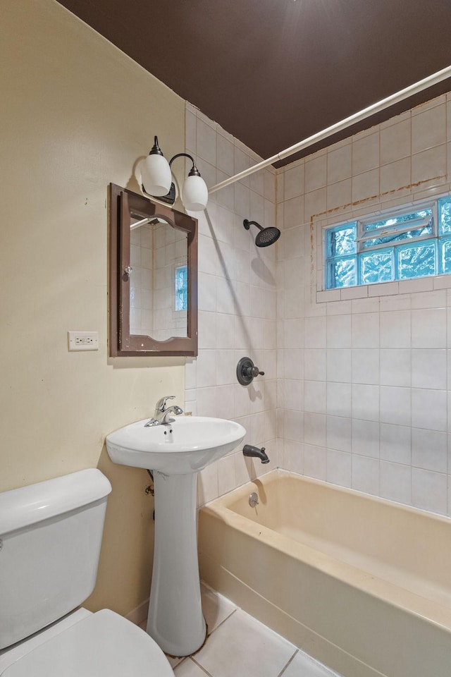 bathroom featuring tile patterned floors, toilet, and tiled shower / bath