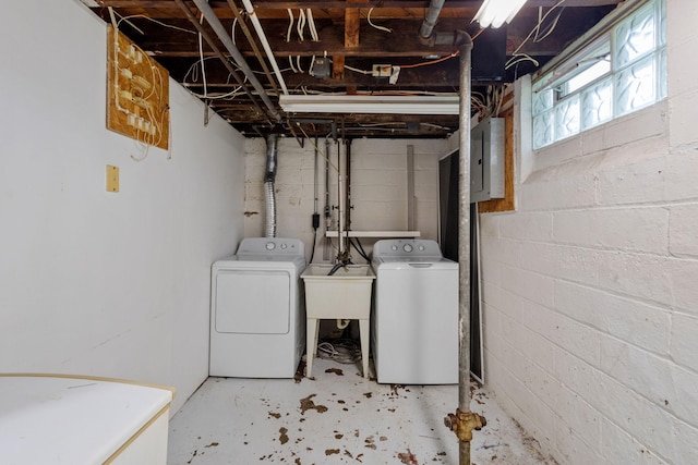 laundry room with washing machine and clothes dryer, electric panel, and sink