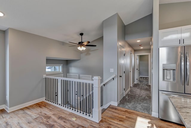 corridor featuring lofted ceiling and light hardwood / wood-style flooring