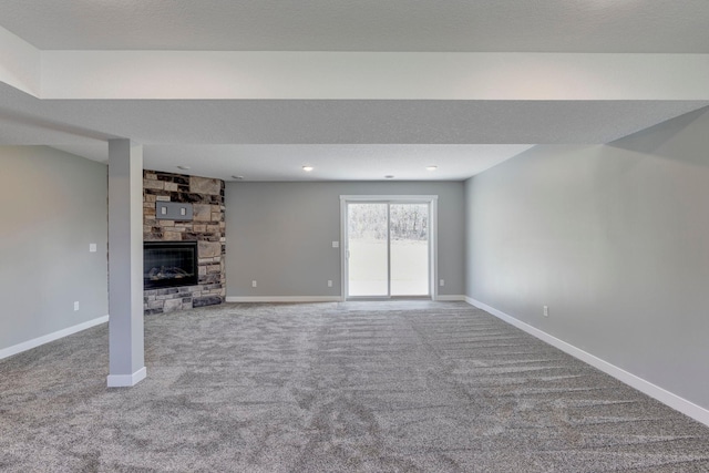 unfurnished living room featuring carpet flooring, a fireplace, and a textured ceiling